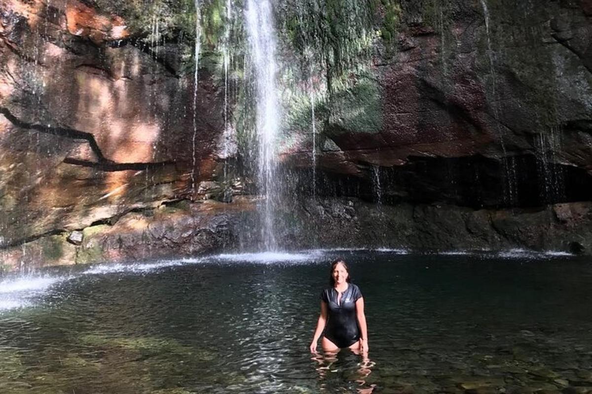 una donna in piedi nell'acqua di fronte a una cascata