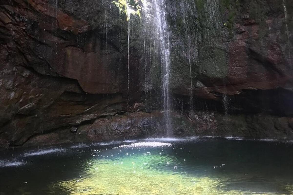una cascata sopra una pozza d'acqua in una grotta