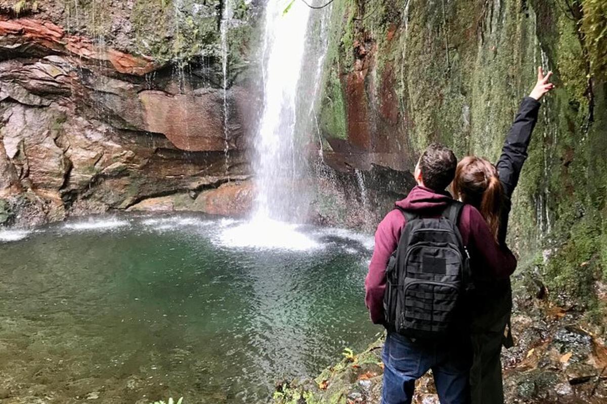 un uomo e una donna in piedi davanti a una cascata