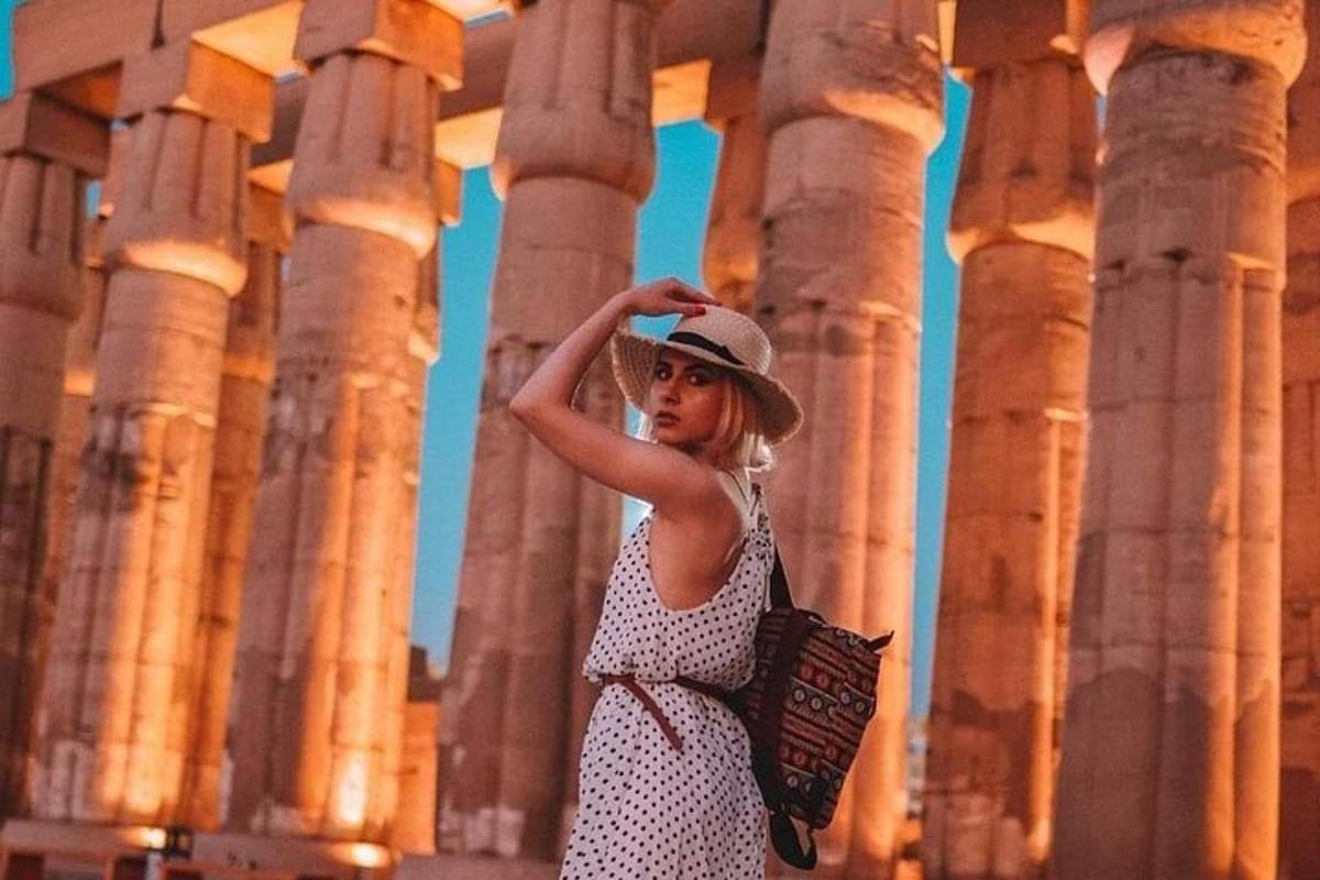 uma mulher usando um chapéu em pé em frente às colunas
