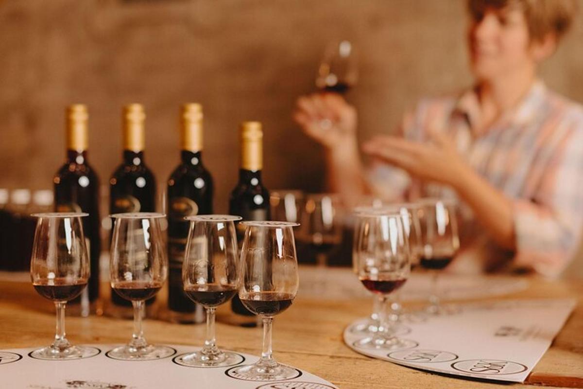 um grupo de taças de vinho sobre uma mesa com garrafas de vinho