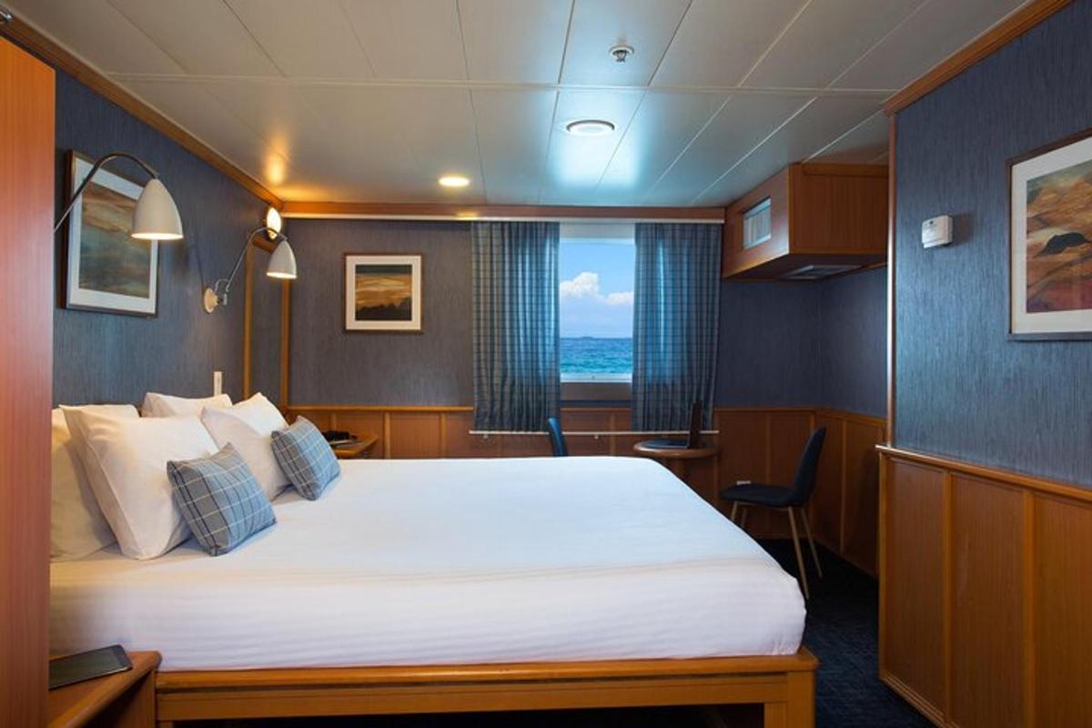 a room with a large bed on a boat
