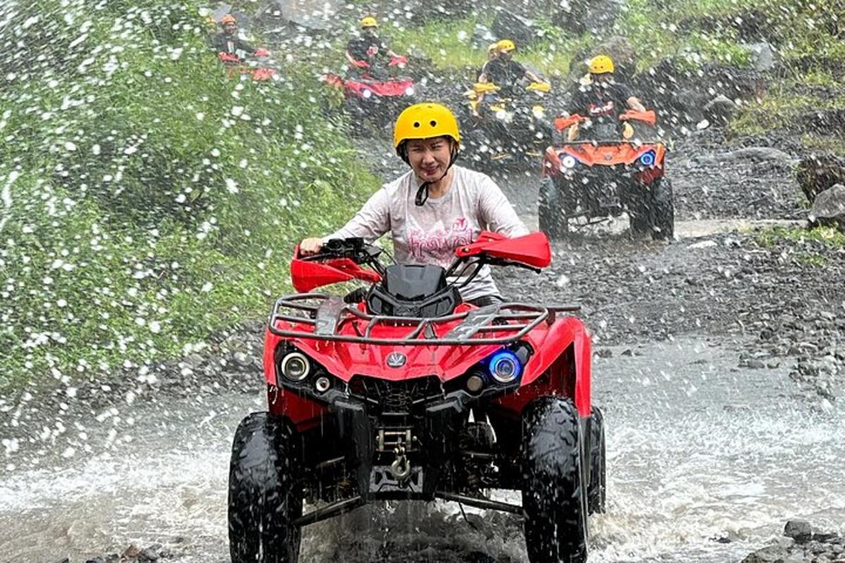 một người đàn ông đang lái xe bốn bánh trong bùn