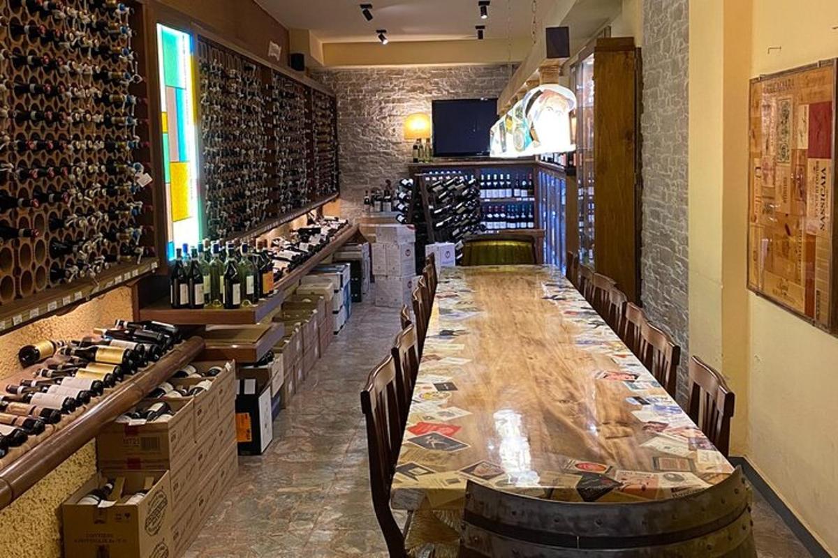 dolga miza v vinski kleti s steklenicami vina