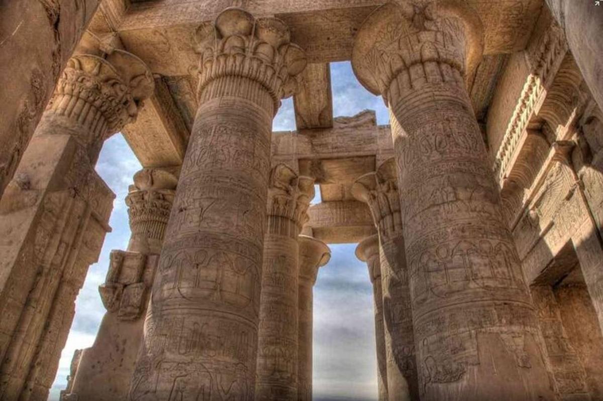 un antico edificio con colonne con sfondo di cielo