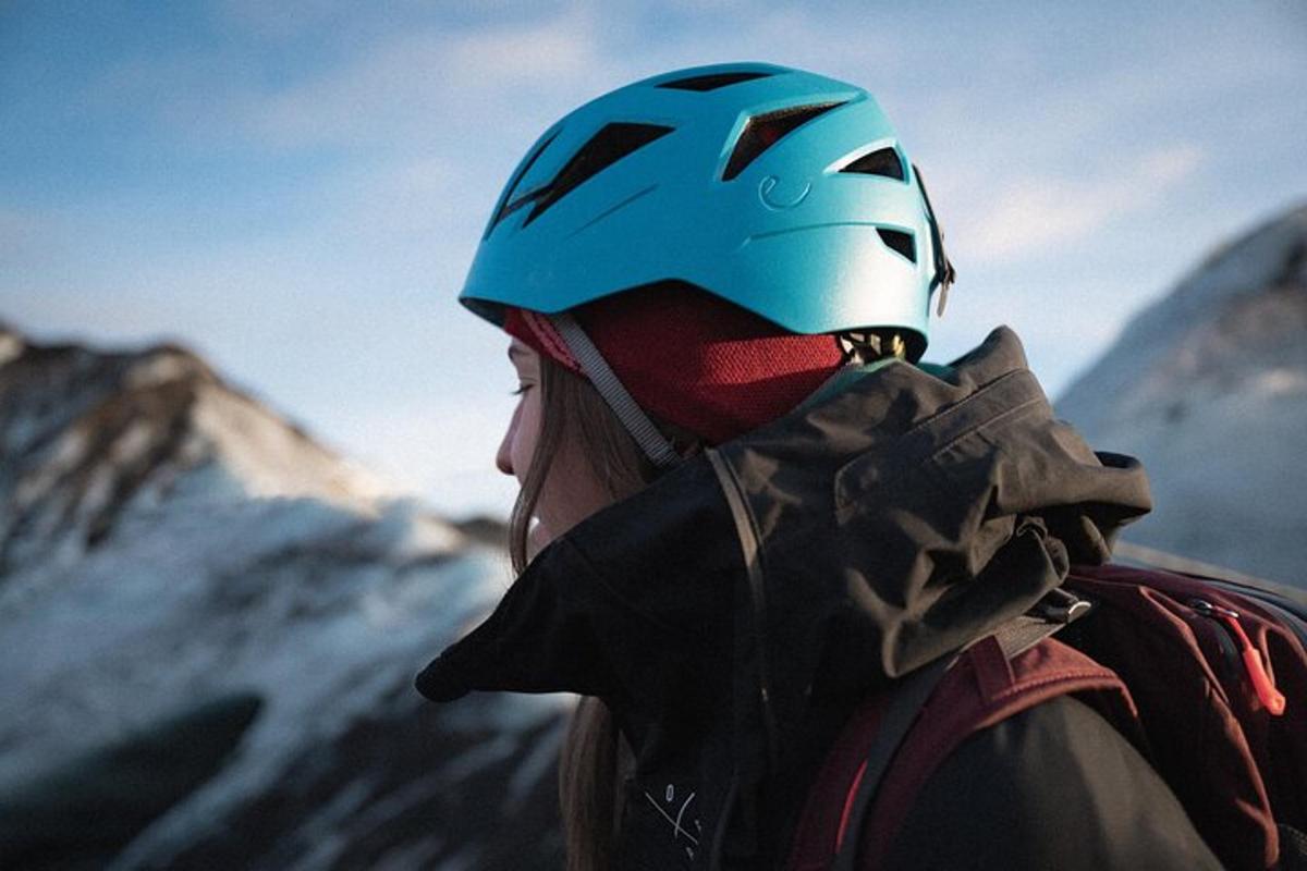 a woman wearing a helmet on top of a mountain