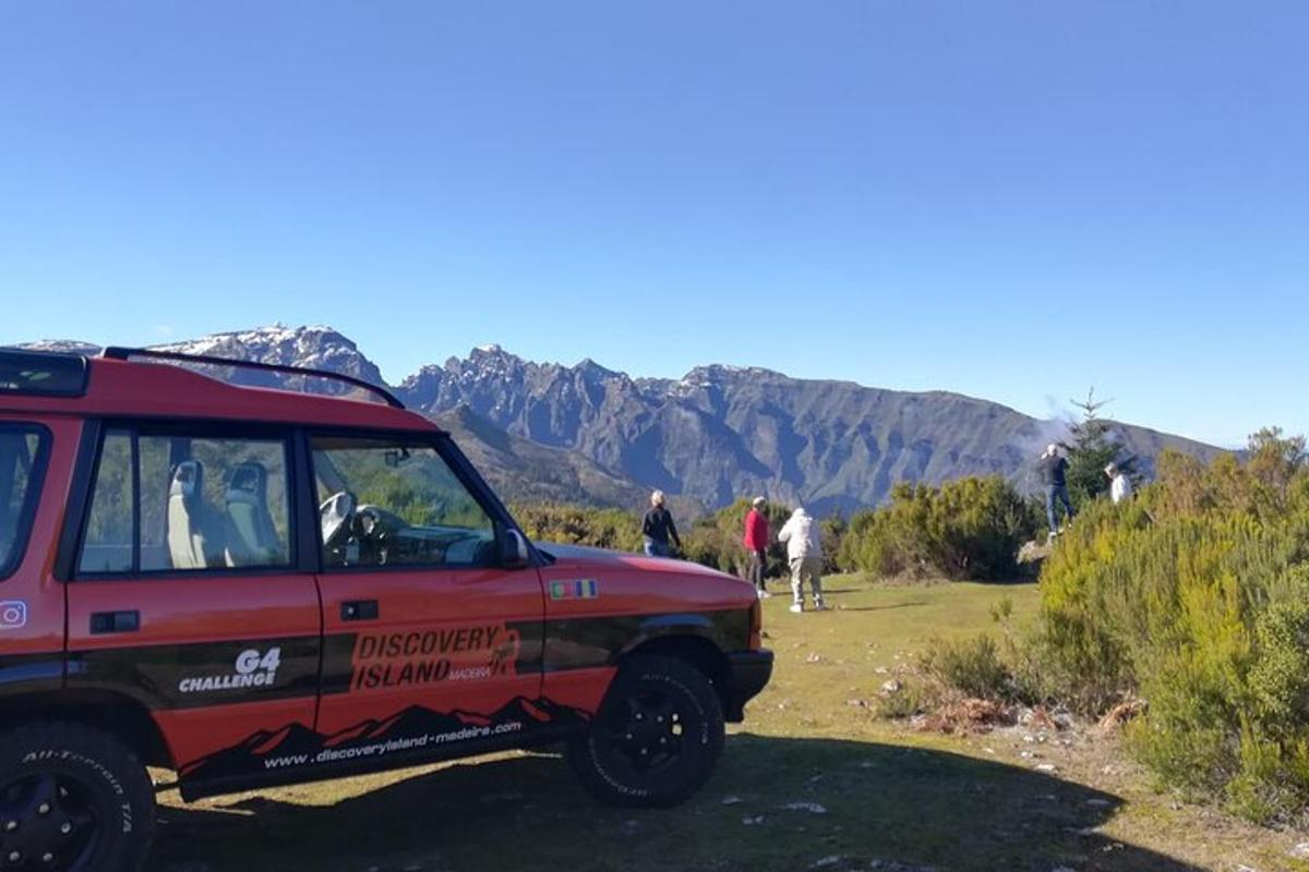 sebuah jip merah diletakkan di tepi gunung