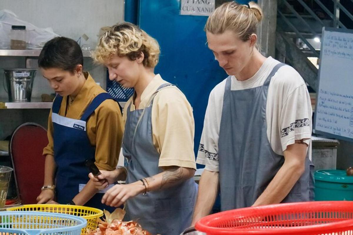 three people standing in a kitchen preparing food