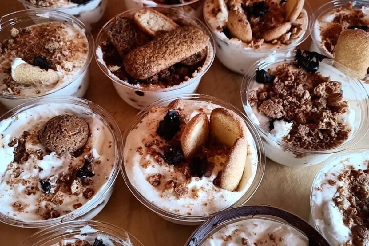 galds, kas klāts ar plastmasas krūzītēm, kas piepildītas ar desertiem