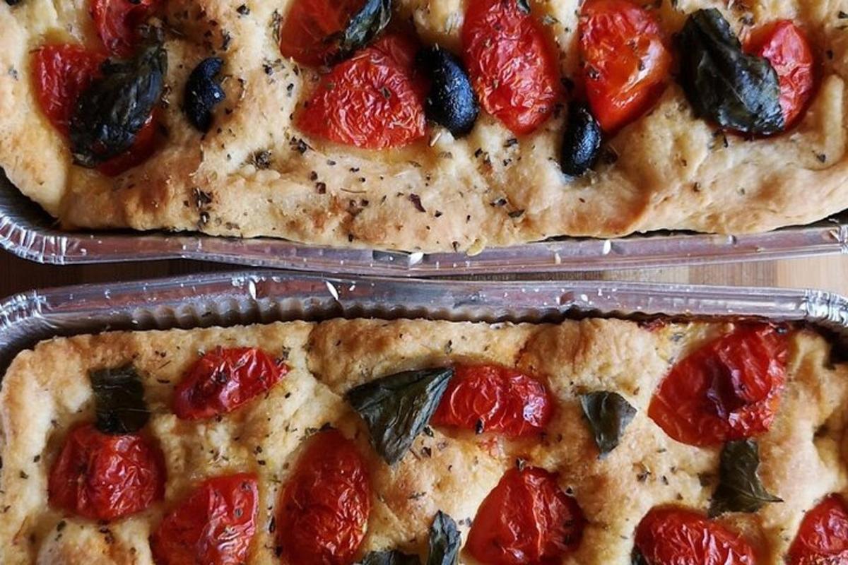 két pizza paradicsommal és aszalt gyümölcsökkel a tetején
