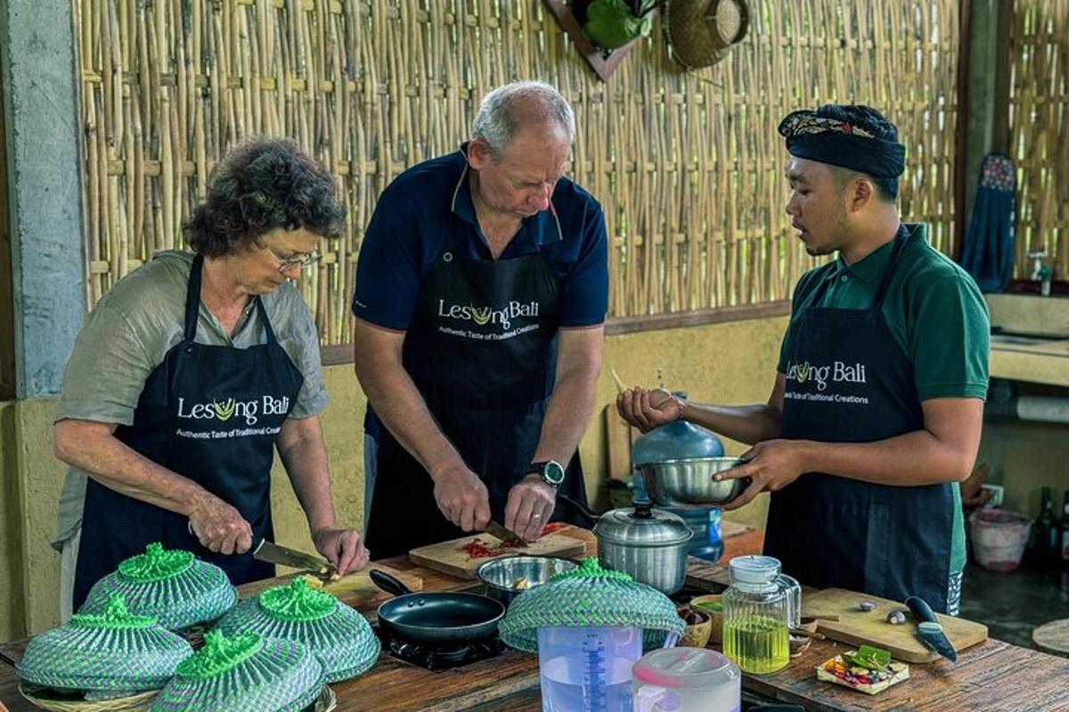 tre persone in cucina che preparano il cibo su un tavolo