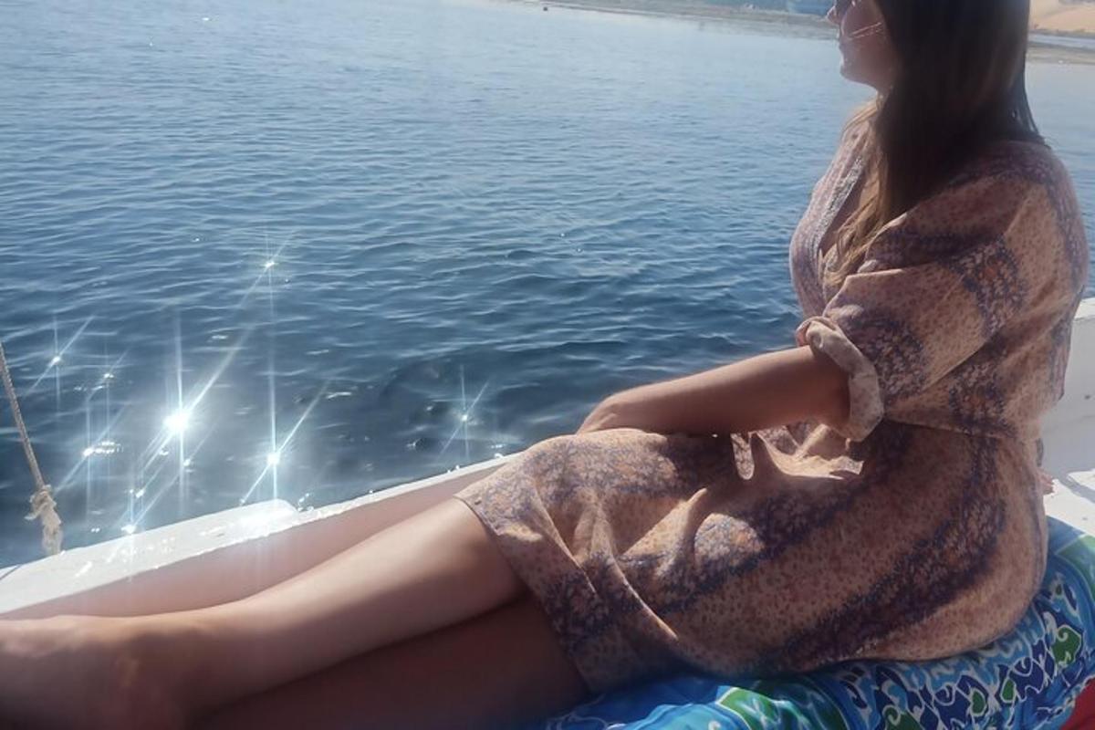 žena sedící na lodi a dívající se na vodu