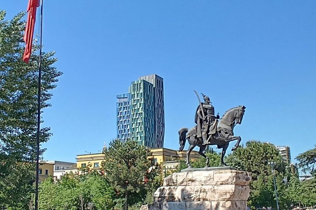 o statuie a unui bărbat călare pe un cal în fața unui oraș