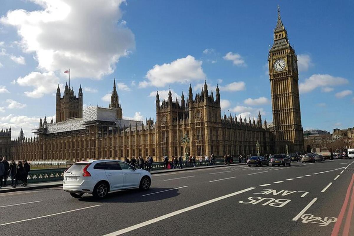 sebuah kereta putih memandu di jalan di hadapan big ben