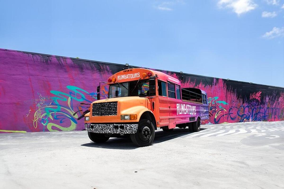 un camion arancione parcheggiato davanti a un muro con graffiti