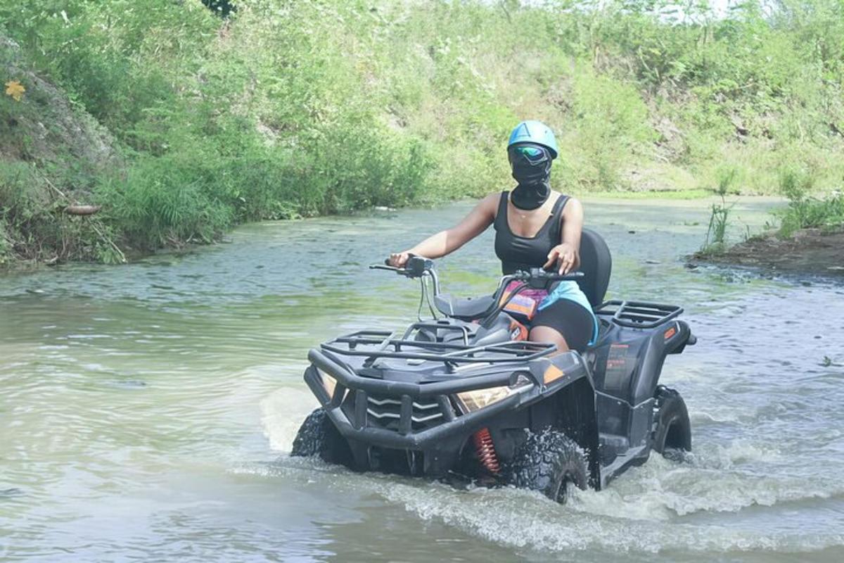 a person riding a wheeler through a river