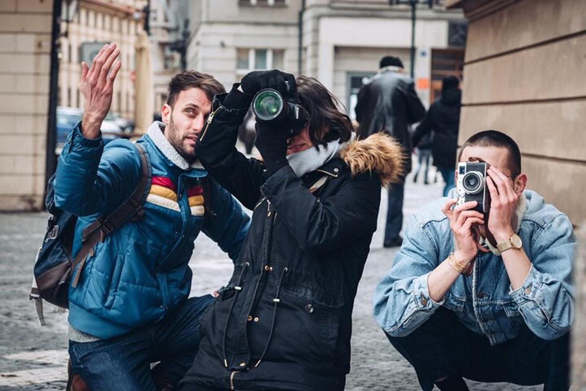 Dos hombres y una mujer tomándose una foto con una cámara