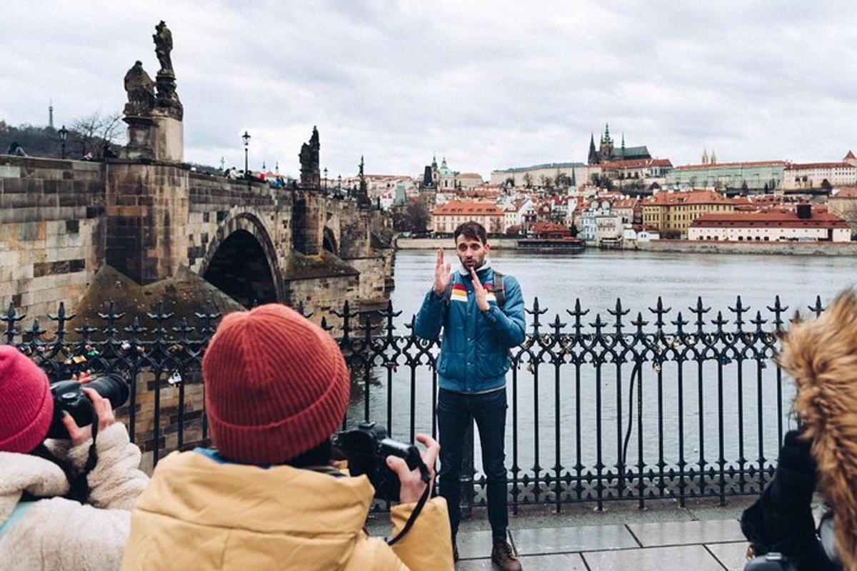 Un hombre parado frente a un río tomando una fotografía.