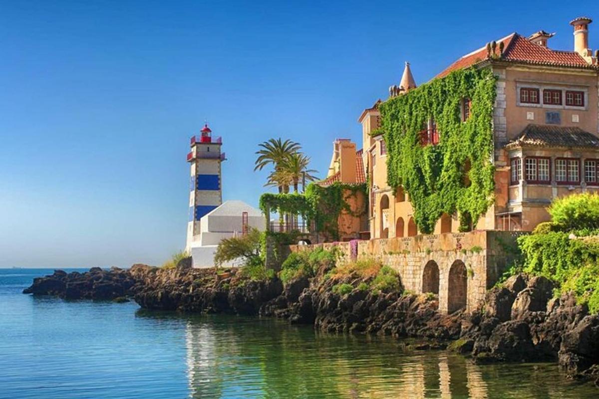 un faro e un edificio accanto a uno specchio d'acqua