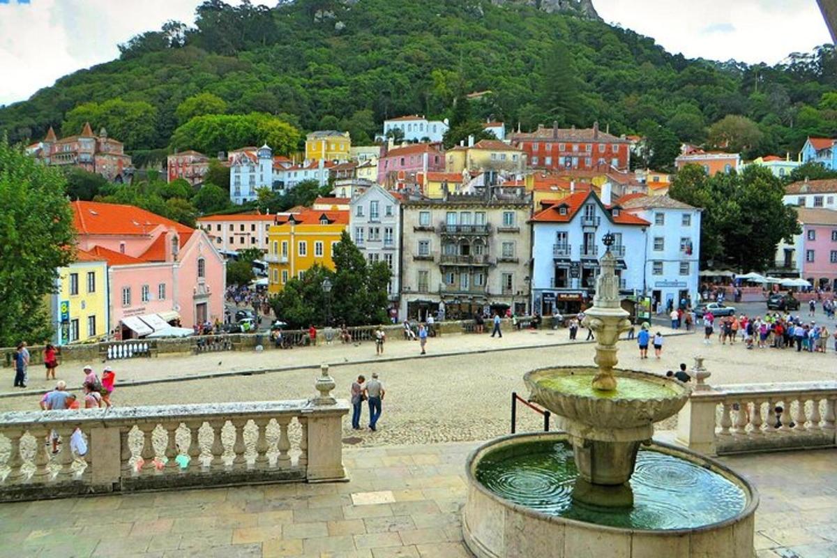 una ciudad con una fuente en frente de un pueblo