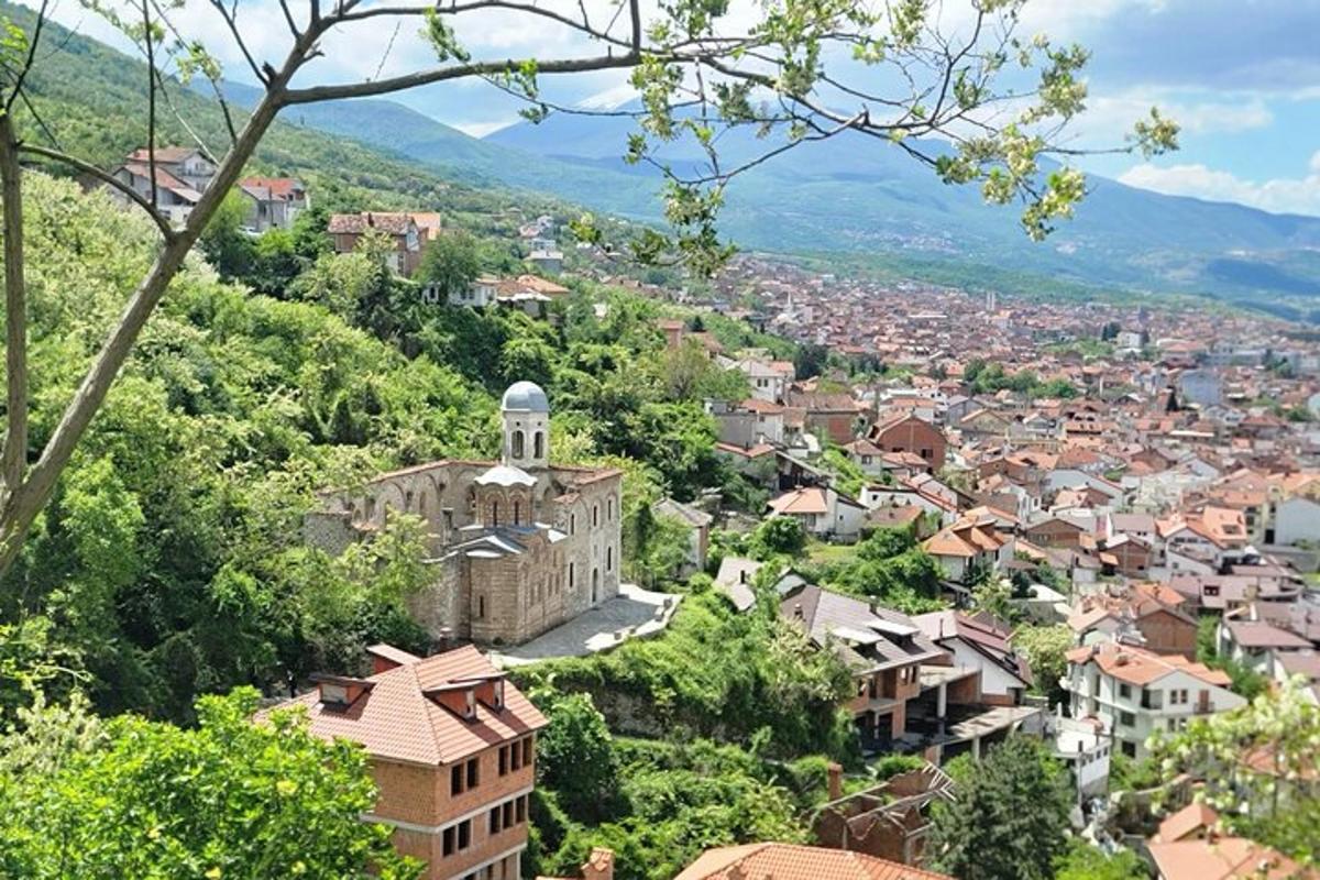 Una vista de una ciudad con una torre de reloj en una colina.