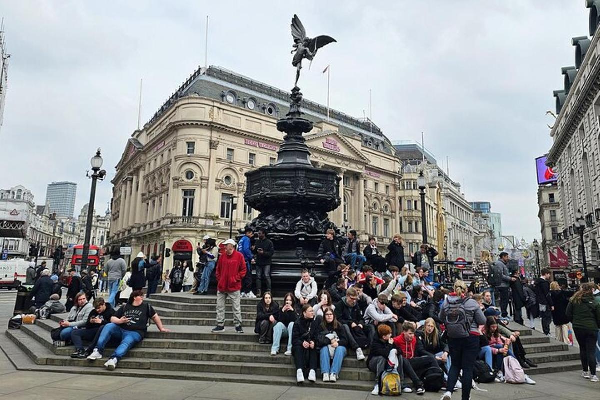 una folla di persone sedute sui gradini davanti a una statua