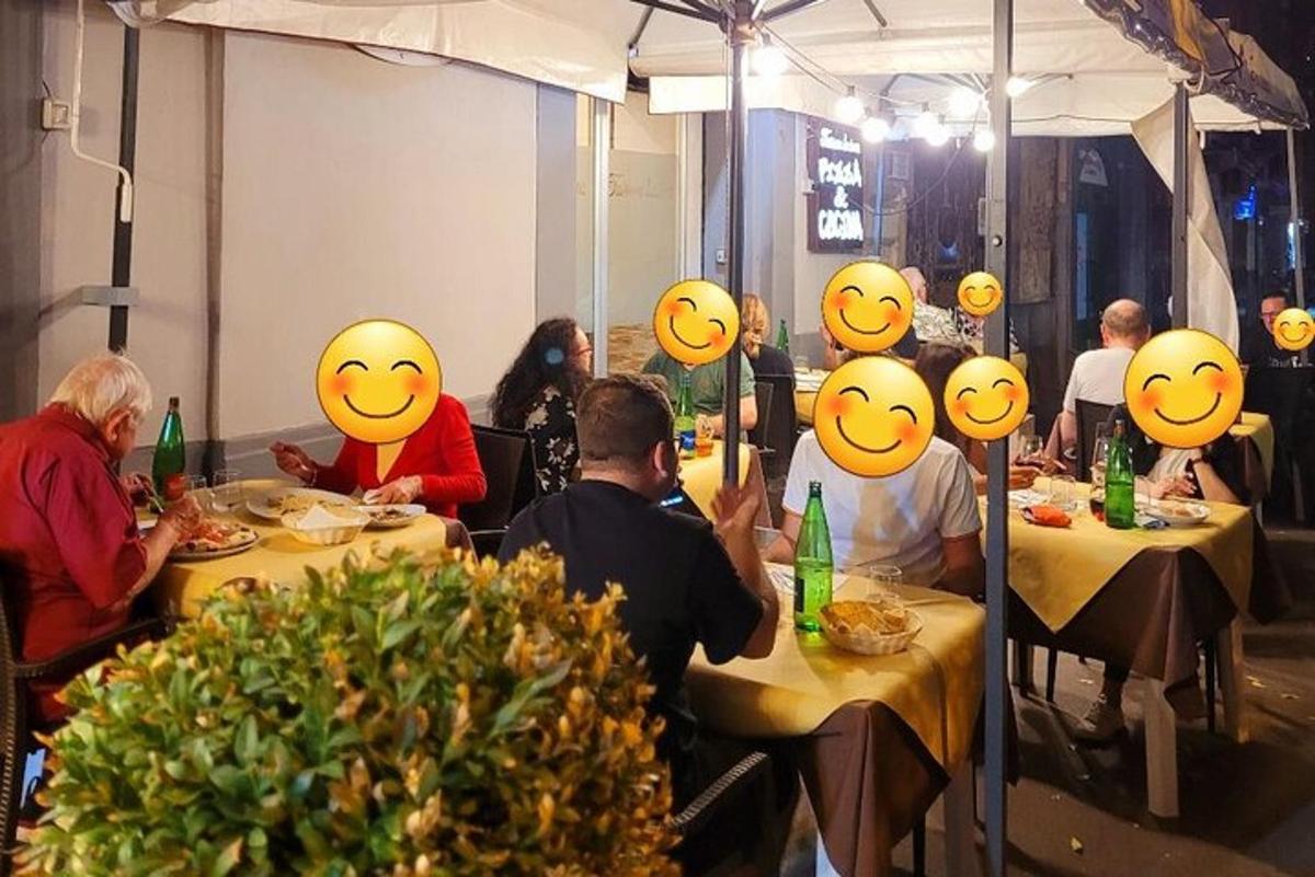skupina lidí sedících u stolů s úsměvy na tvářích
