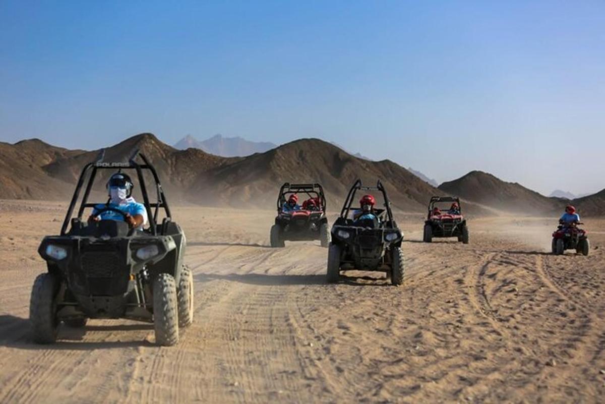 un grup de persones conduint quads al desert