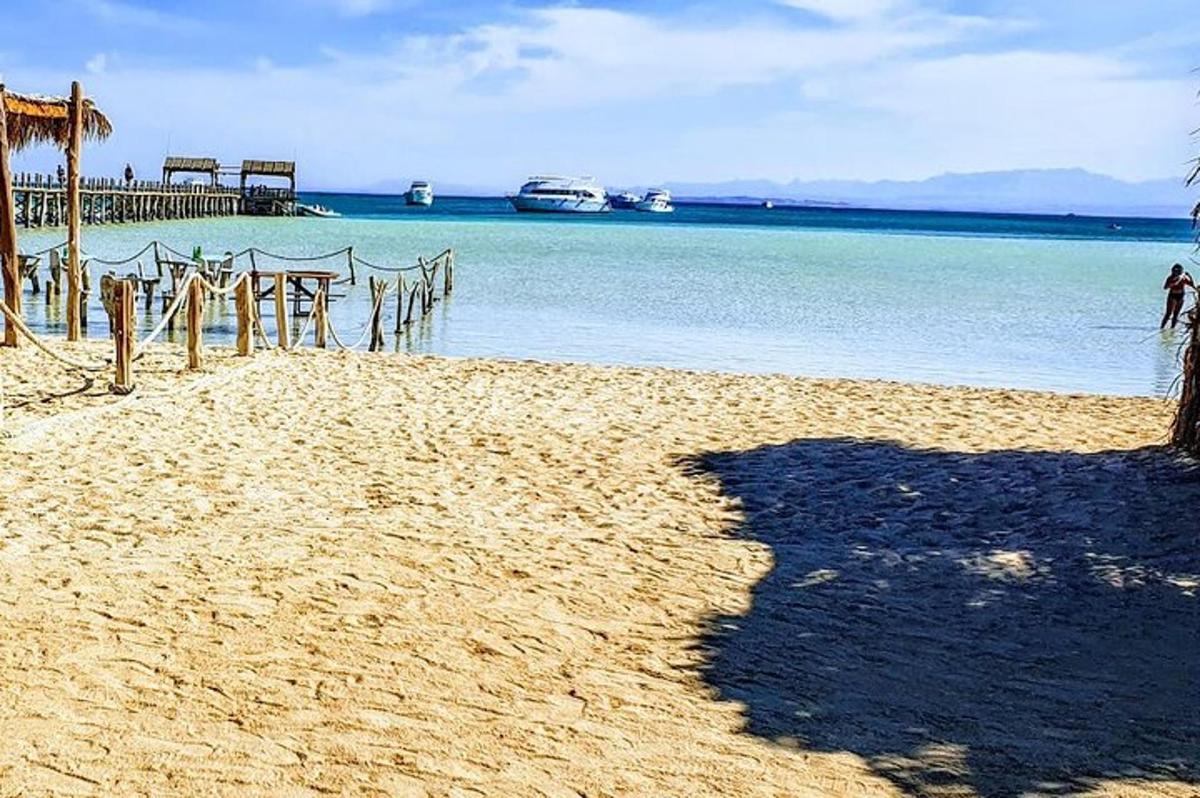 Una playa con un muelle de madera y el agua