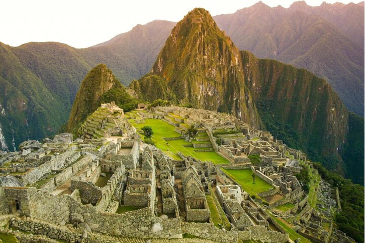 Una vista aérea de Machu Picchu con montañas al fondo.