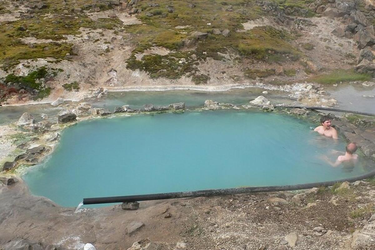 двама души плуват в басейн със синя вода