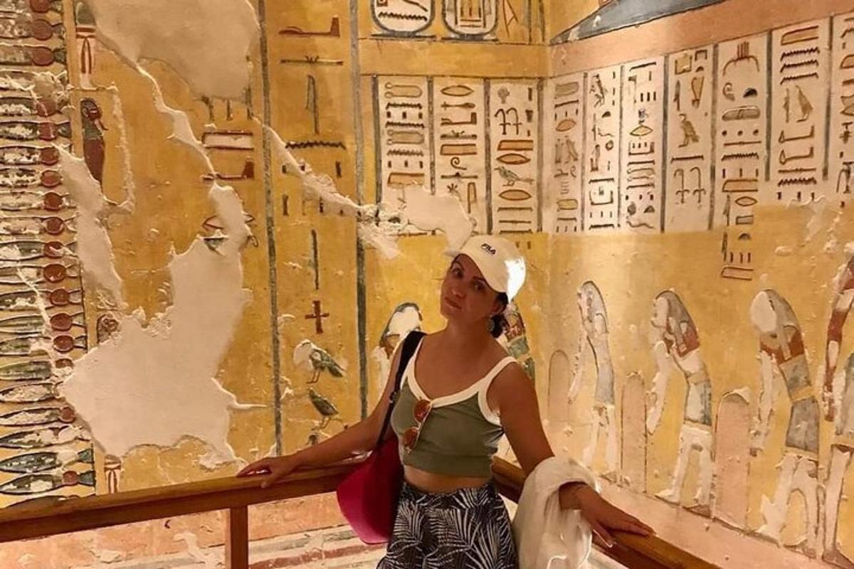 žena stojící před zdí se starověkými hieroglyfy