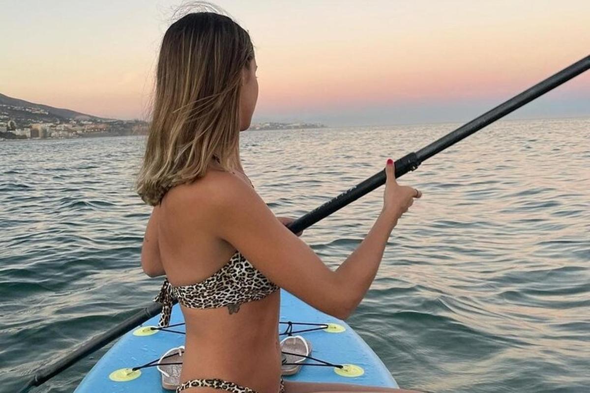dívka v bikinách na paddleboardu na vodě