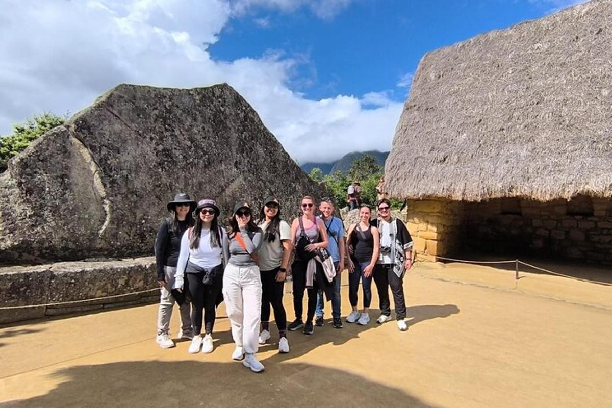 um grupo de pessoas em pé em frente a duas grandes rochas