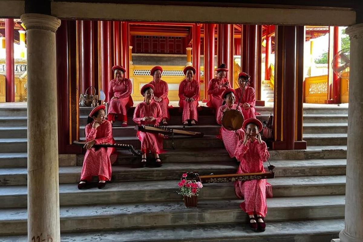 sekumpulan gadis berpakaian seragam merah jambu duduk di tangga bangunan