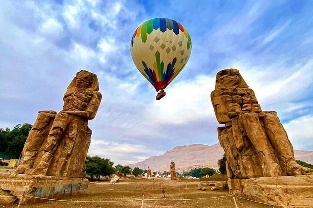 balon udara panas terbang di atas dua patung batu