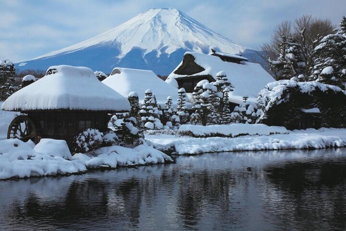 uma montanha coberta de neve em frente a um corpo d'água