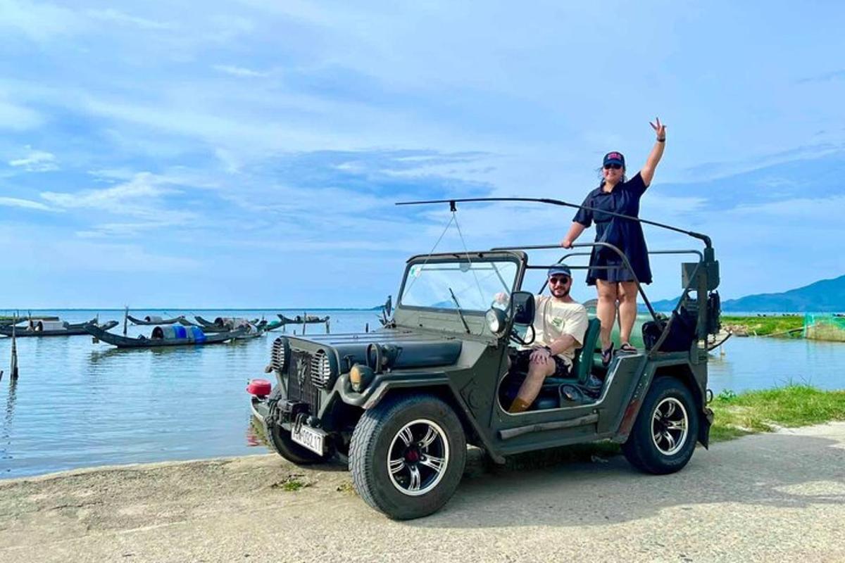 một người đàn ông và một người phụ nữ đứng trên nóc xe jeep