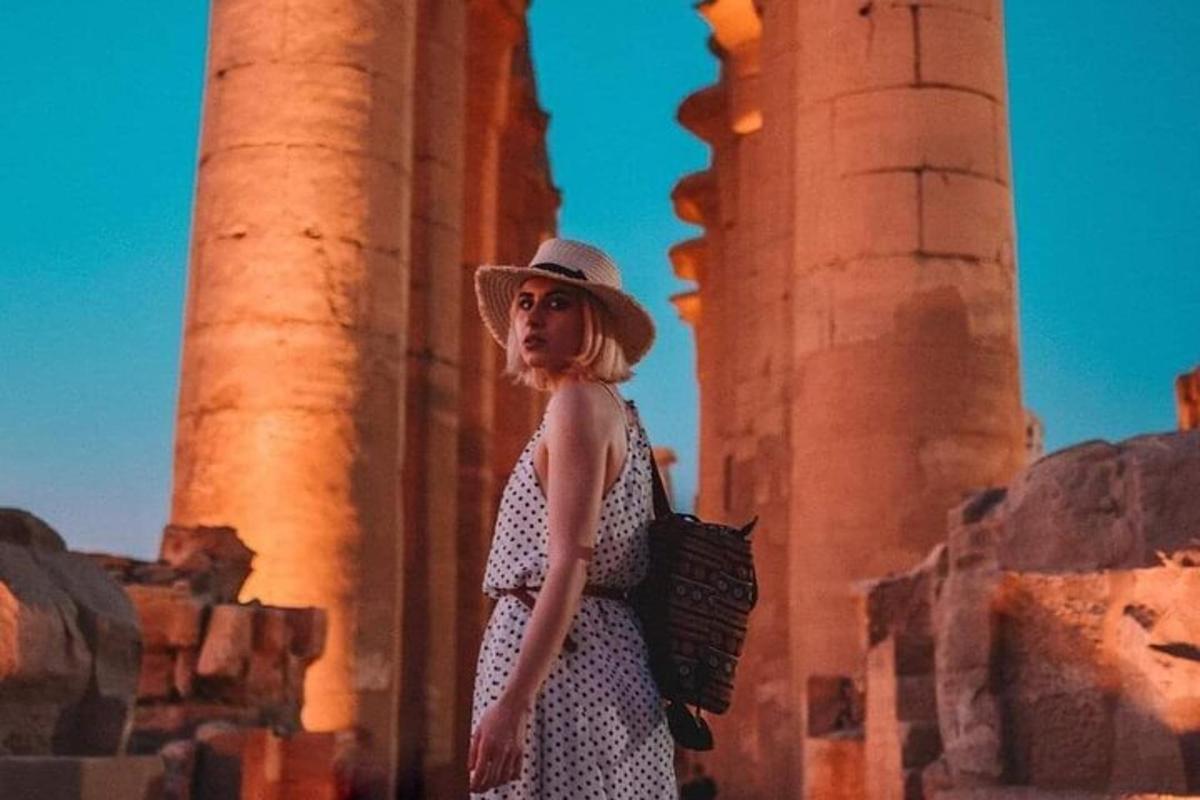 una donna con un cappello in piedi davanti alle colonne