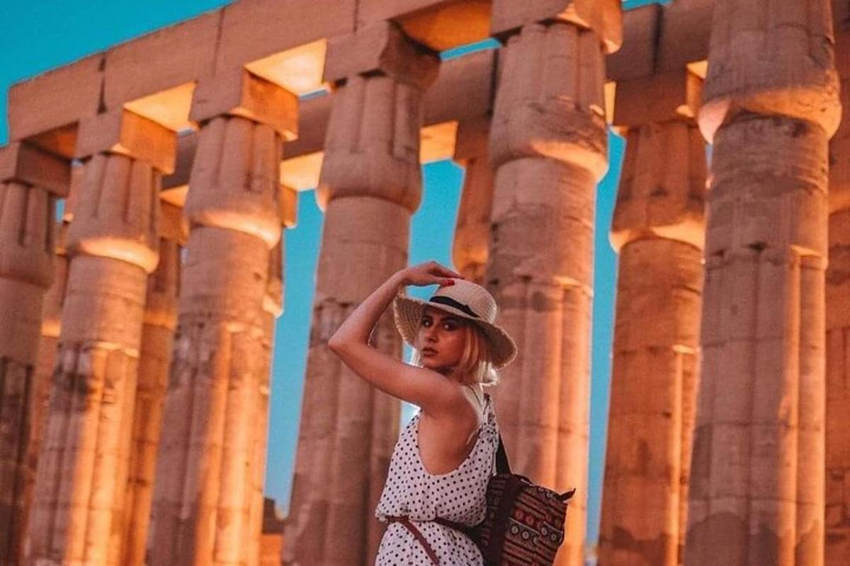 una donna che indossa un cappello in piedi davanti alle colonne