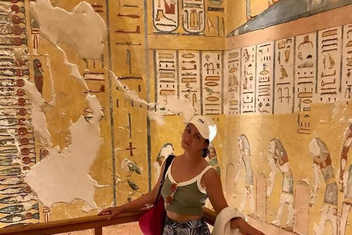 una donna in piedi davanti a un muro con una scritta sopra