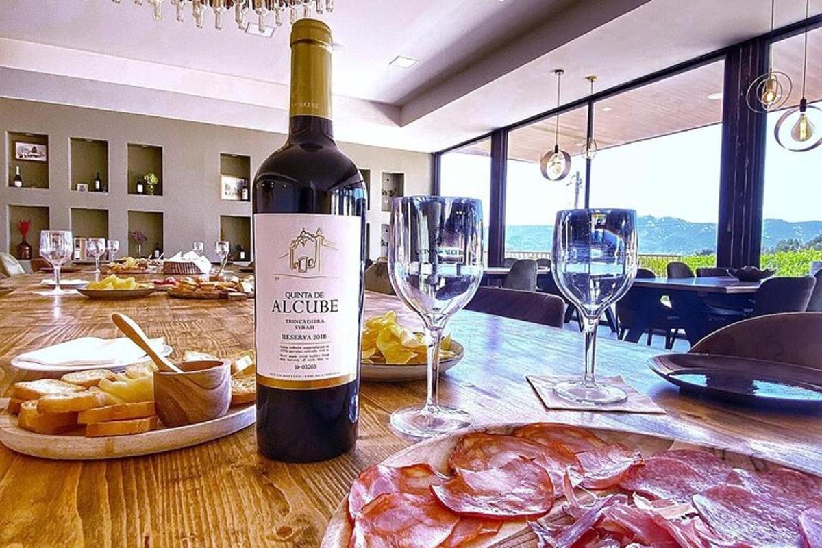 a bottle of wine sitting on a table with wine glasses