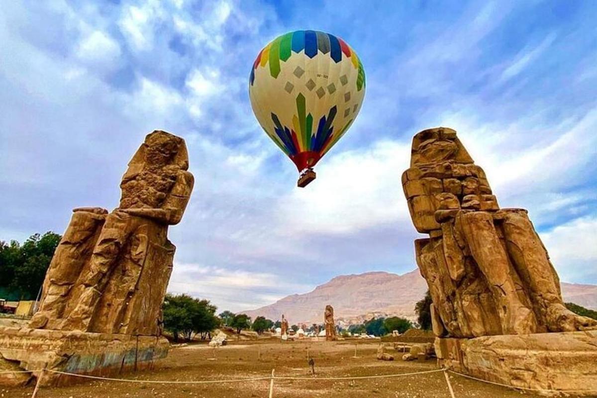 Un globo aerostático volando sobre dos estatuas de piedra