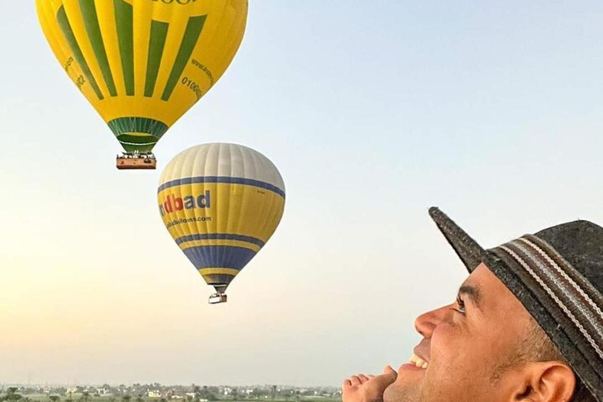 Un hombre mira hacia arriba y ve dos globos aerostáticos.