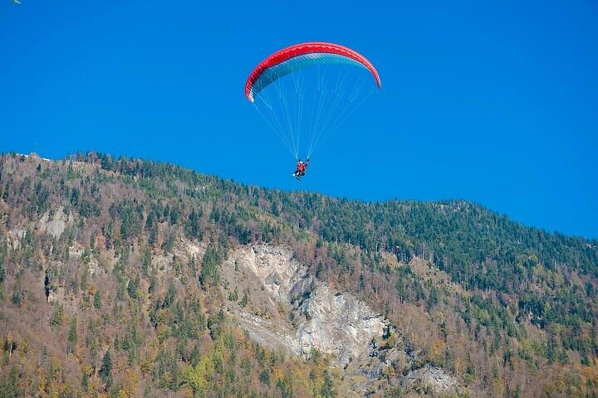 a person flying a parachute over a mountain