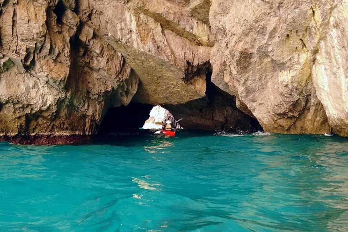una persona su una barca in una grotta nell'acqua