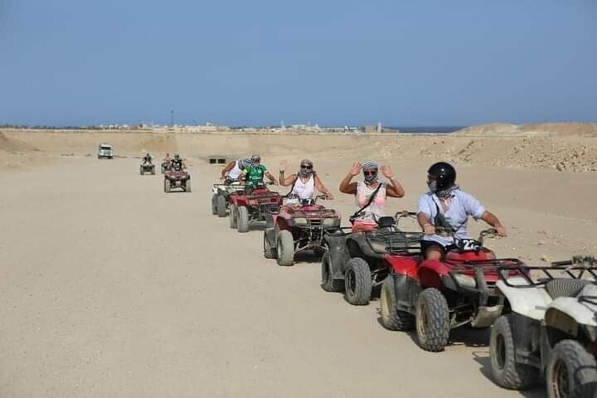 Un grupo de personas conduciendo vehículos todo terreno en el desierto.