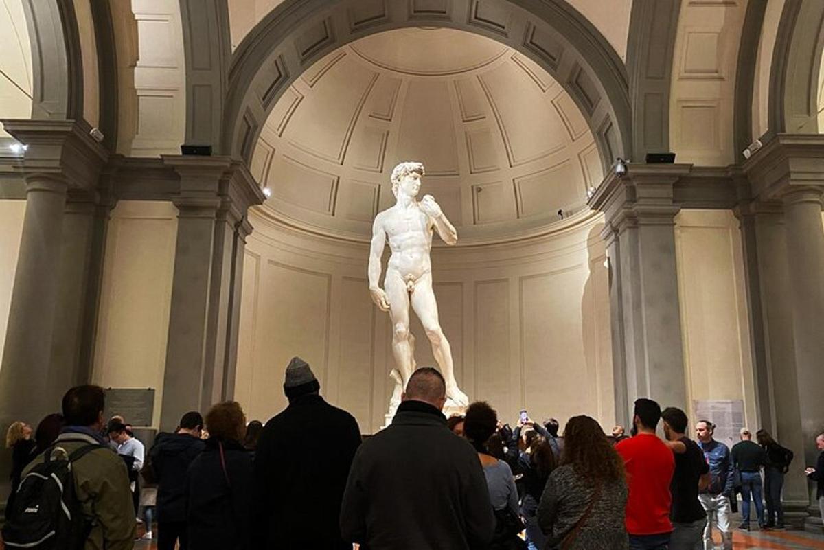 una multitud de gent mirant una estàtua en un museu