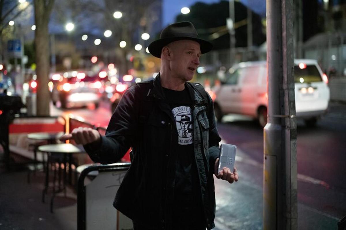 Ένας άντρας με καπέλο που στέκεται σε έναν δρόμο