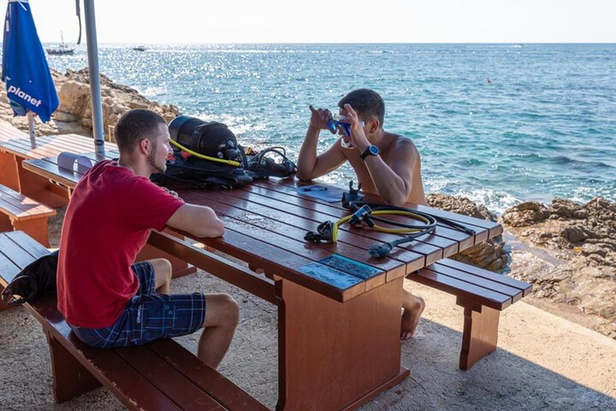 Kaks meest istuvad piknikulaua taga ja pildistavad ookeani